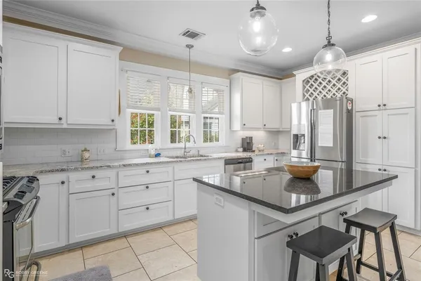 a kitchen with a sink dishwasher a stove and white cabinets with wooden floor