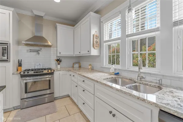 a kitchen with granite countertop a sink stainless steel appliances and cabinets