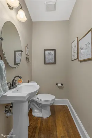 a bathroom with a toilet a sink and mirror