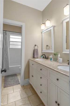a bathroom with a double vanity sink and a mirror