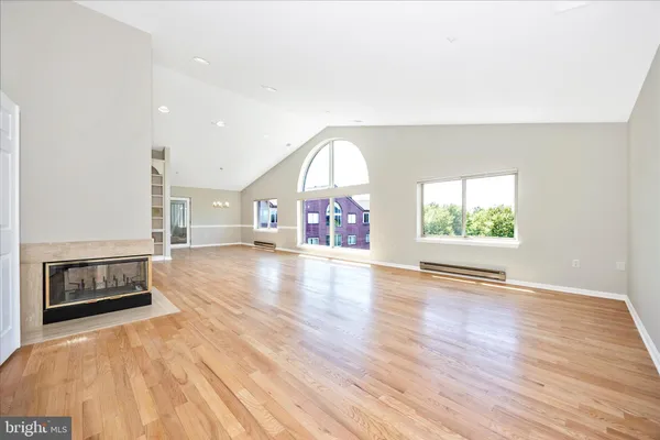 a view of an empty room window and wooden floor
