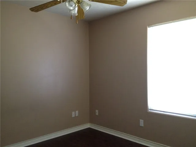 a view of a small space with wooden floor and a window