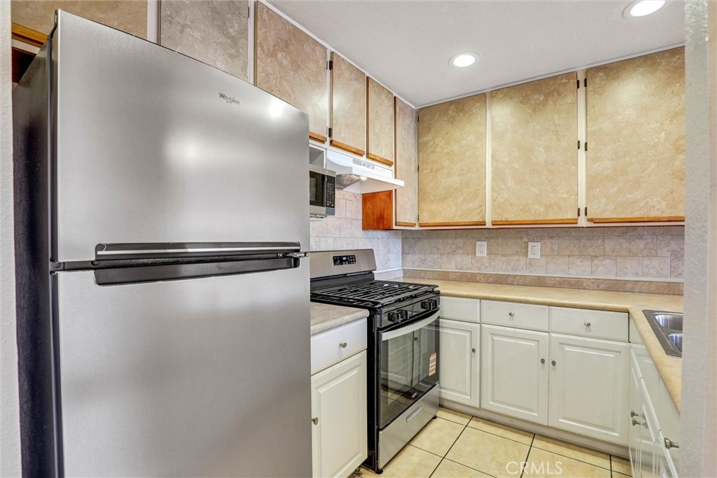 450 East 4th Street, Unit 337 Santa Ana, CA 92701 - Photo 7 of 26 a kitchen with stainless steel appliances granite countertop a refrigerator a sink and white cabinets
