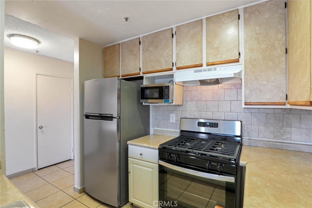 450 East 4th Street, Unit 337 Santa Ana, CA 92701 - Photo 8 of 26 a kitchen with stainless steel appliances granite countertop a refrigerator and a stove