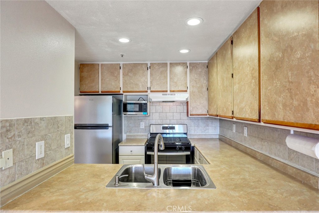 450 East 4th Street, Unit 337 Santa Ana, CA 92701 - Photo 9 of 26 a kitchen with stainless steel appliances granite countertop a sink stove and refrigerator