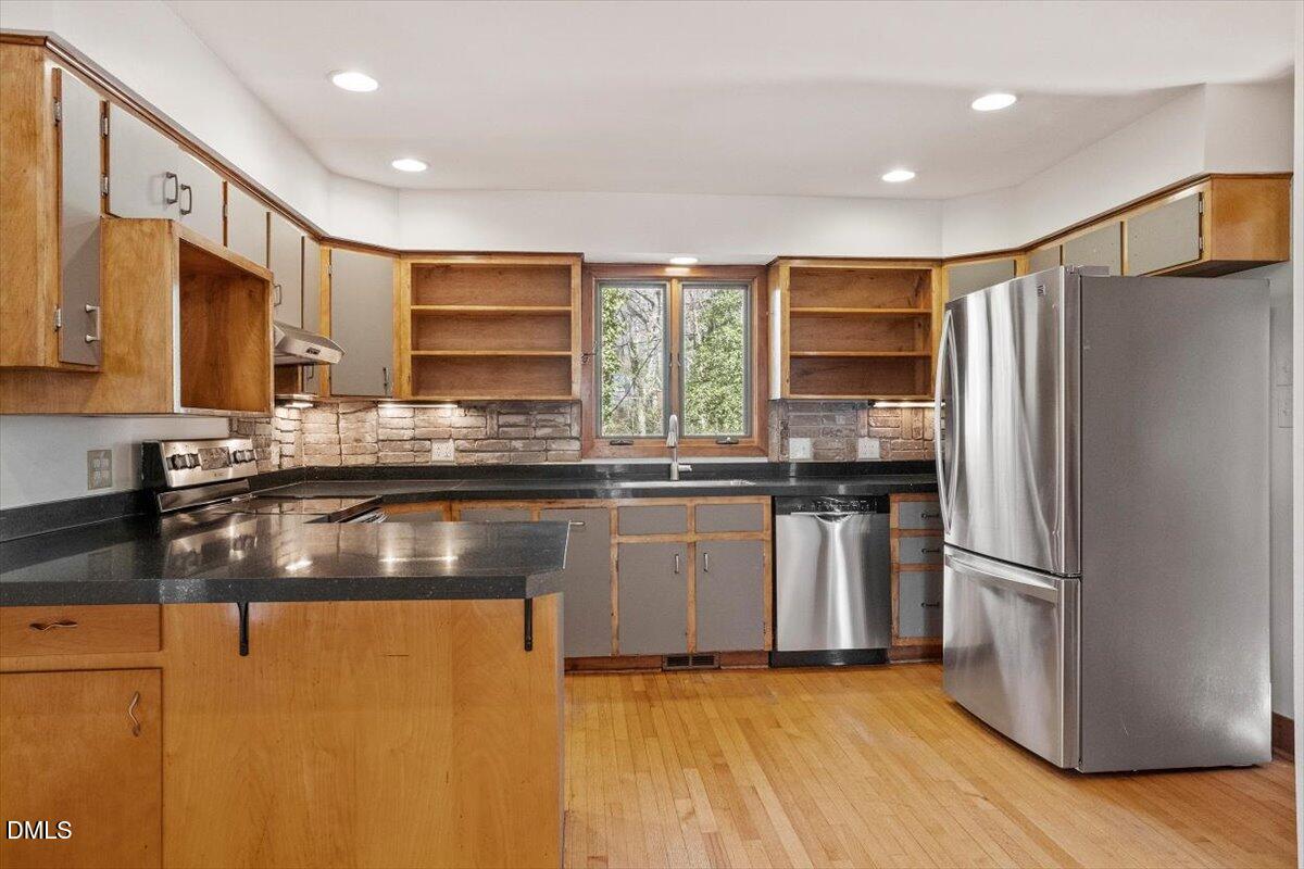 4805 Rembert Drive Raleigh, NC 27612 - Photo 8 of 45 a kitchen with stainless steel appliances granite countertop a refrigerator a sink a stove a microwave and island