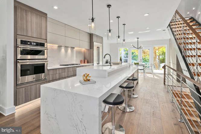 a kitchen with stainless steel appliances granite countertop a sink a stove and a wooden floors