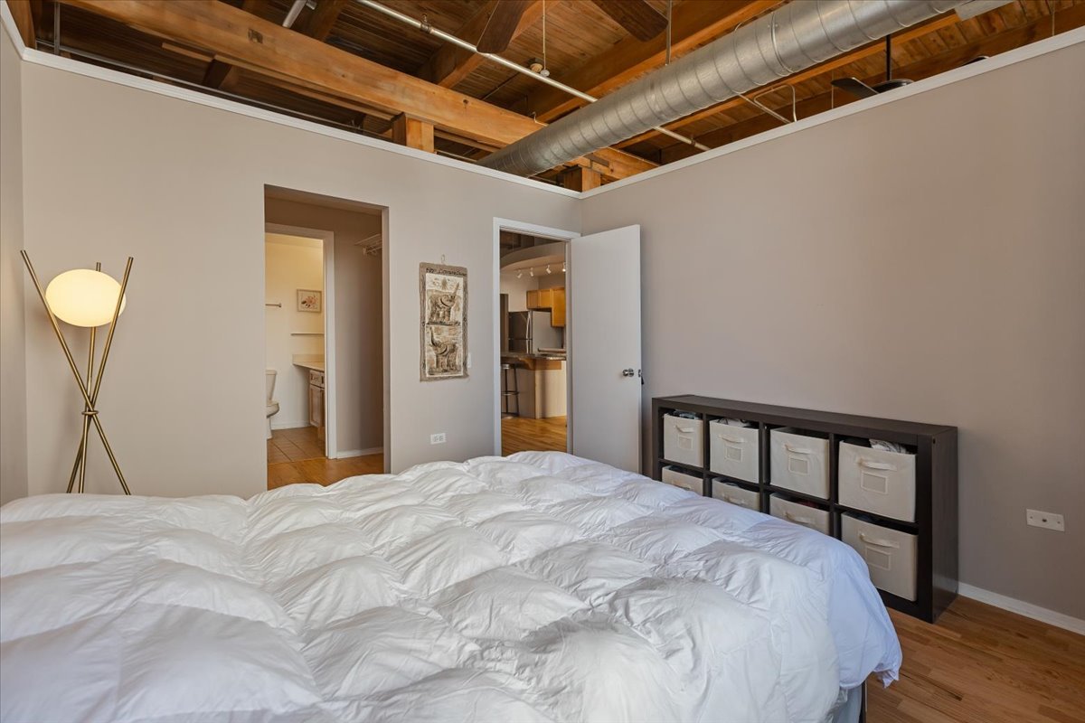 1632 South Indiana Avenue, Unit 403 Chicago, IL 60616 - Photo 13 of 23 a bedroom with a bed and a large window