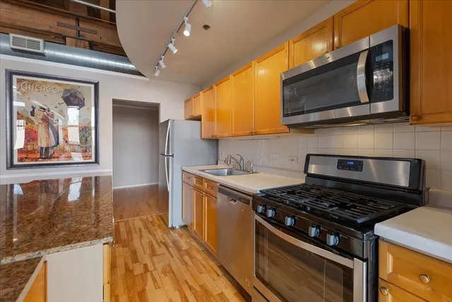 a kitchen with stainless steel appliances granite countertop a stove and a microwave