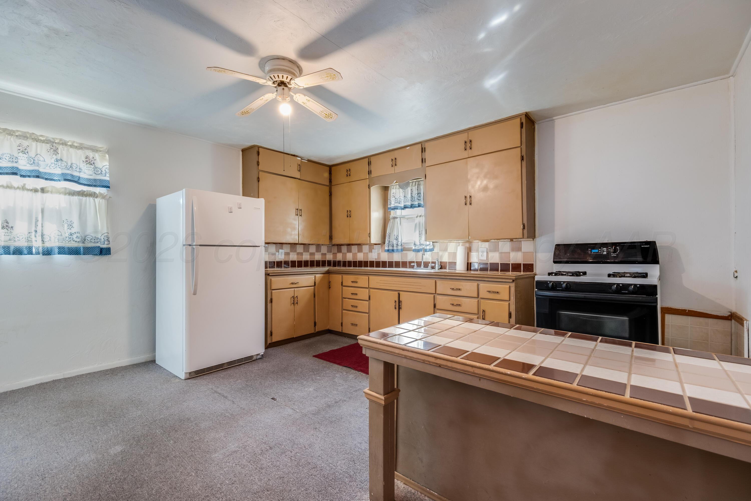 106 South Canadian Street Wheeler, TX 79096 - Photo 7 of 20 a kitchen with a refrigerator and a sink