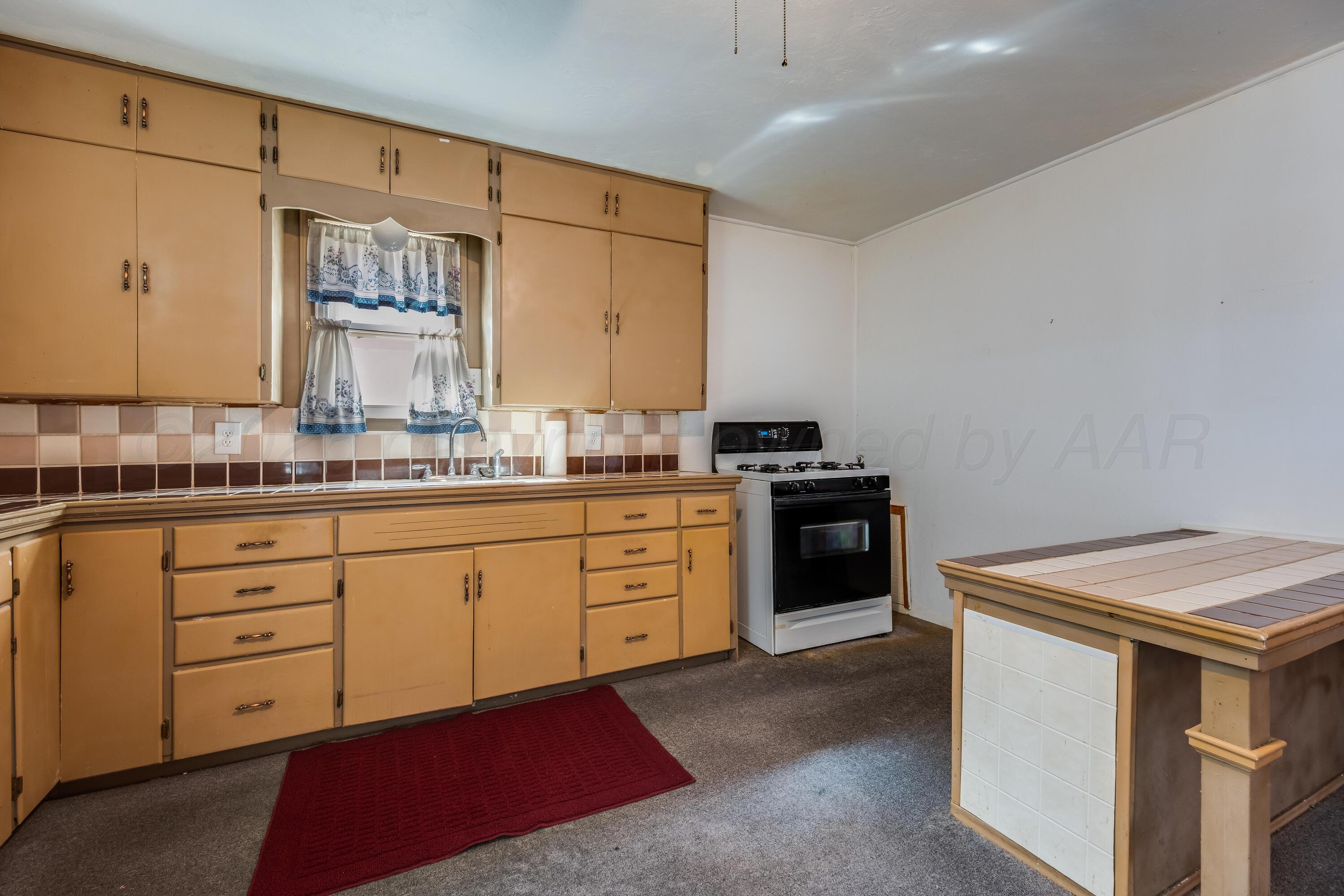 106 South Canadian Street Wheeler, TX 79096 - Photo 8 of 20 a kitchen with a stove oven and sink