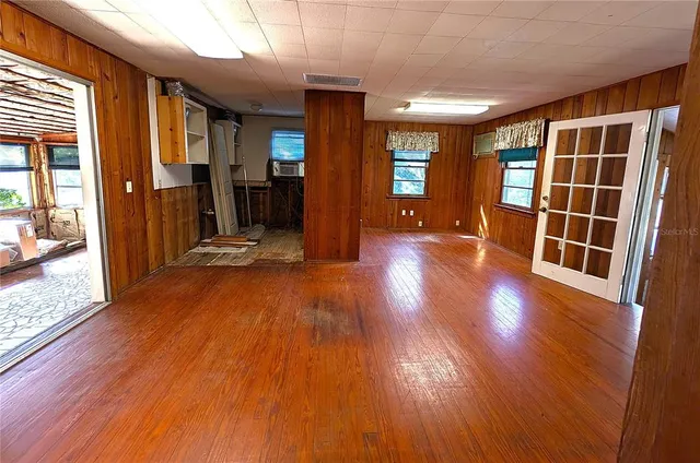 a view of empty room with wooden floor and windows