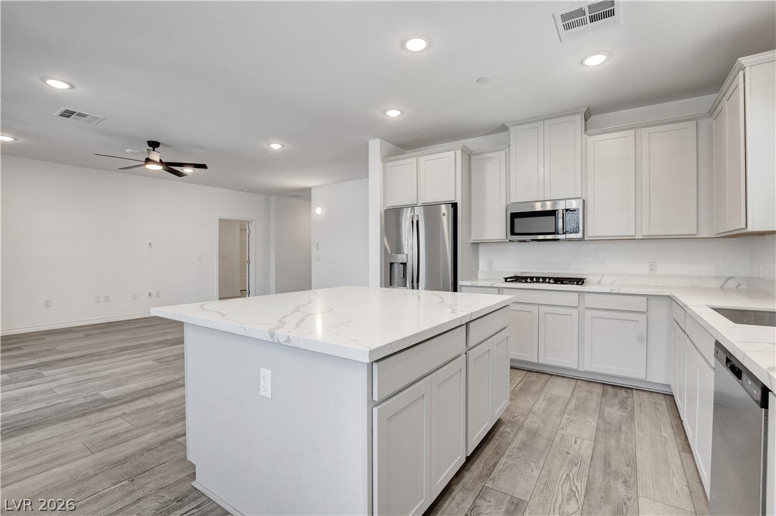 2555 Hampton Road, Unit 2207 Henderson, NV 89052 - Photo 19 of 74 Culinary dreams come alive in this kitchen, featuring an expansive island, gleaming stainless steel appliances, and sleek stone countertops.