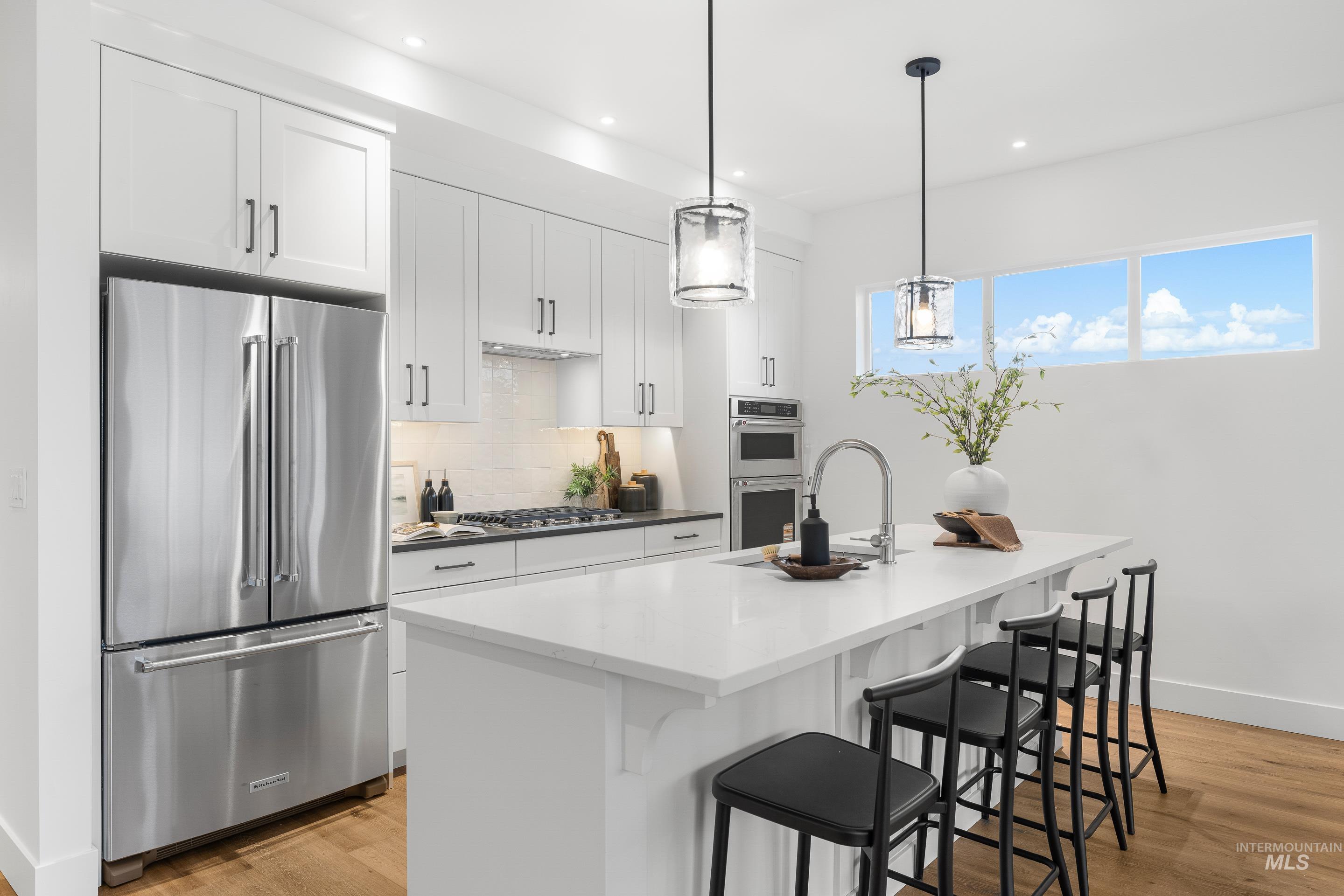 3071 North Lapis Avenue Meridian, ID 83646 - Photo 10 of 50 Kitchen featuring appliances with stainless steel finishes, white cabinets, backsplash, a kitchen bar, and recessed lighting
