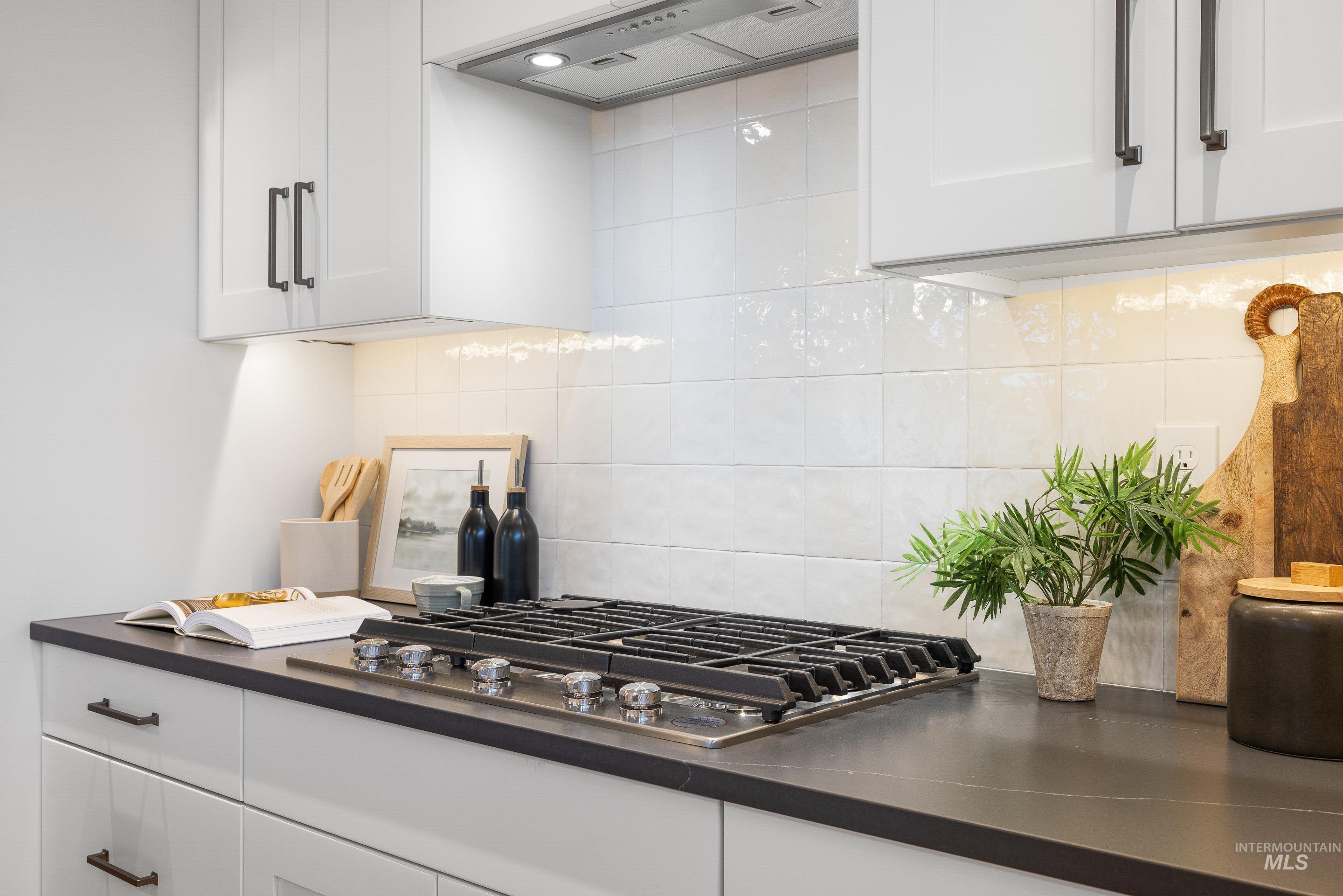 3071 North Lapis Avenue Meridian, ID 83646 - Photo 13 of 50 Kitchen featuring decorative backsplash, white cabinets, and extractor fan