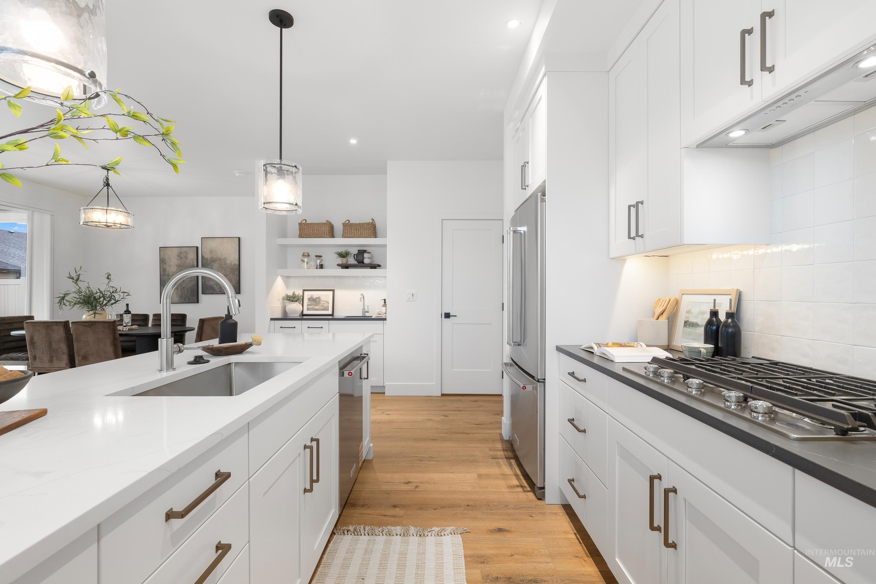 3071 North Lapis Avenue Meridian, ID 83646 - Photo 15 of 50 Kitchen with white cabinetry, tasteful backsplash, appliances with stainless steel finishes, light wood-style flooring, and recessed lighting