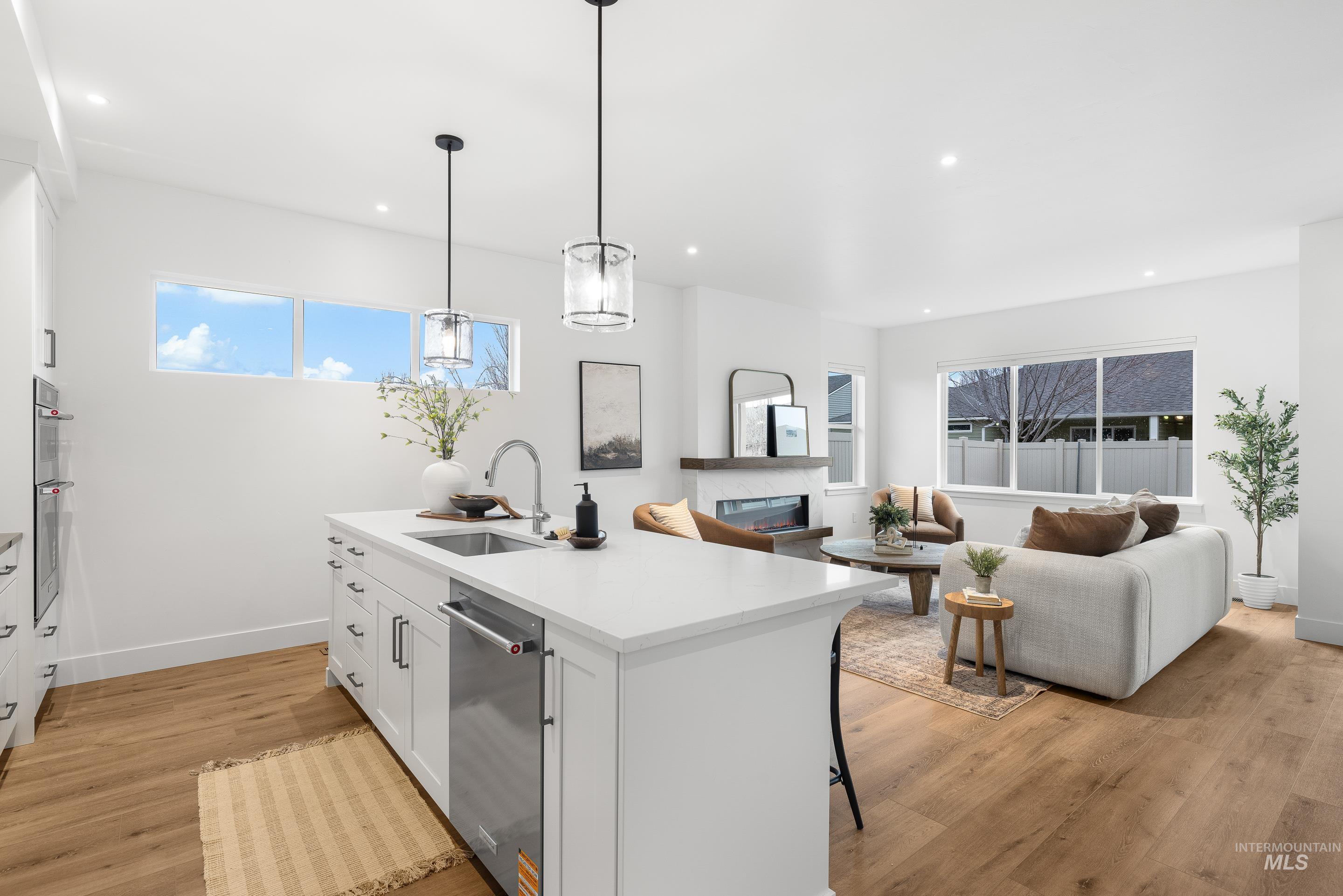3071 North Lapis Avenue Meridian, ID 83646 - Photo 50 of 50 Kitchen featuring white cabinetry, a kitchen breakfast bar, open floor plan, light wood-style floors, and recessed lighting