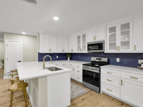a kitchen with white cabinets stainless steel appliances and sink