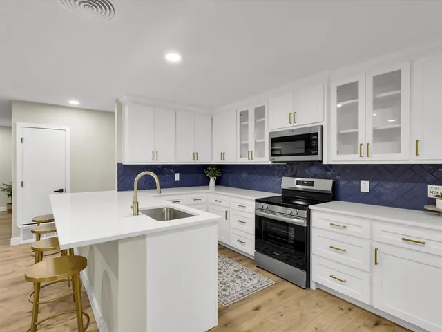 a kitchen with white cabinets stainless steel appliances and sink