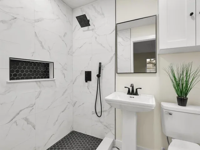 a bathroom with a sink toilet and shower