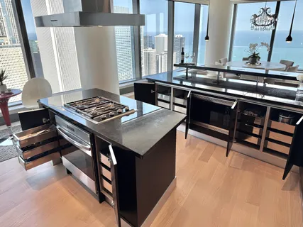 a kitchen with stainless steel appliances granite countertop a stove a sink and a refrigerator