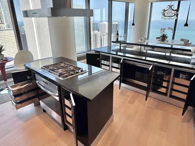 a kitchen with stainless steel appliances granite countertop a stove a sink and a refrigerator