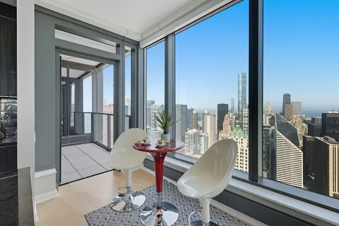 a dining room with furniture and a floor to ceiling window