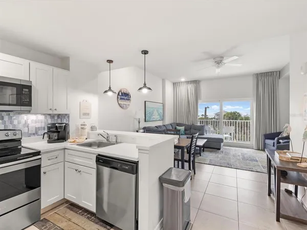 a kitchen with stainless steel appliances granite countertop a refrigerator a stove a sink dishwasher and a refrigerator with wooden floor