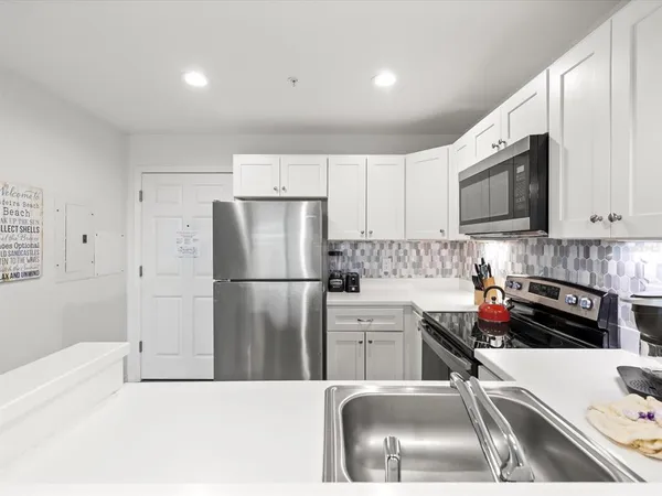 a bedroom with a large bed and a flat tv screen on dresser