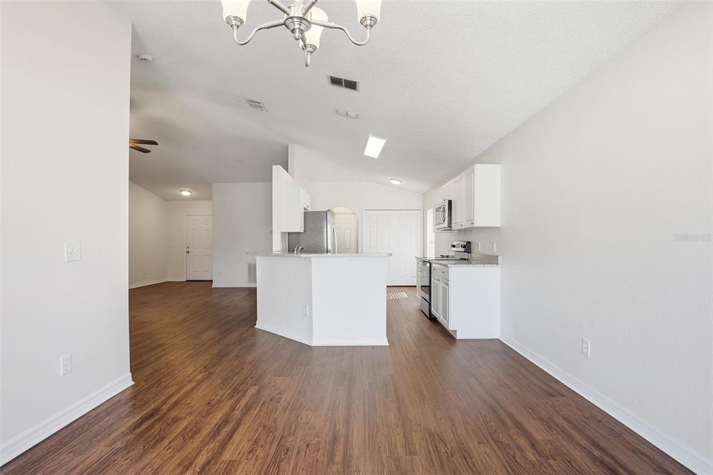 914 Stallion Way Valrico, FL 33594 - Photo 20 of 38 a view of kitchen and empty room with wooden floor