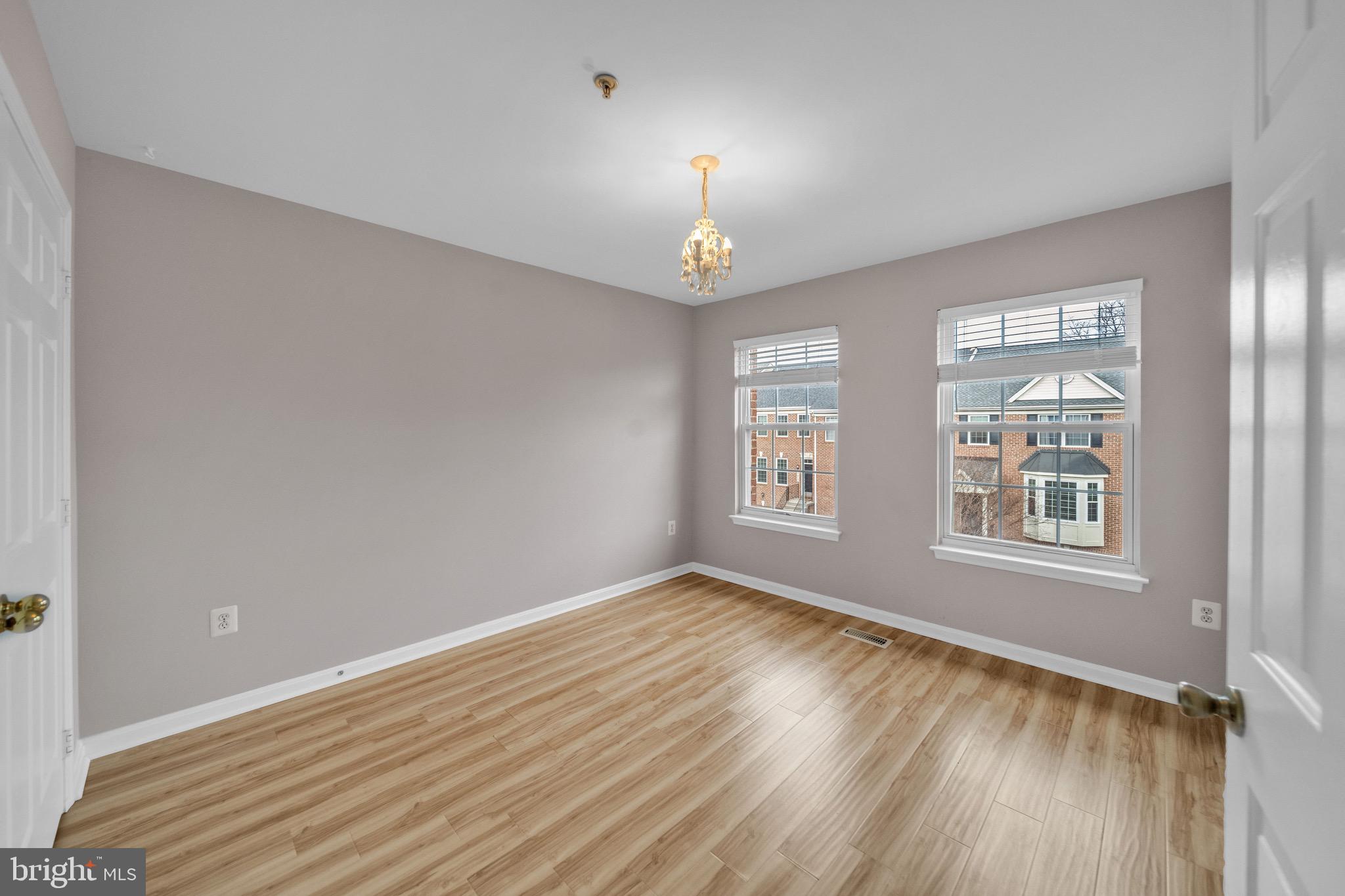 122 Longpoint Way Gaithersburg, MD 20878 - Photo 14 of 37 an empty room with wooden floor chandelier and windows