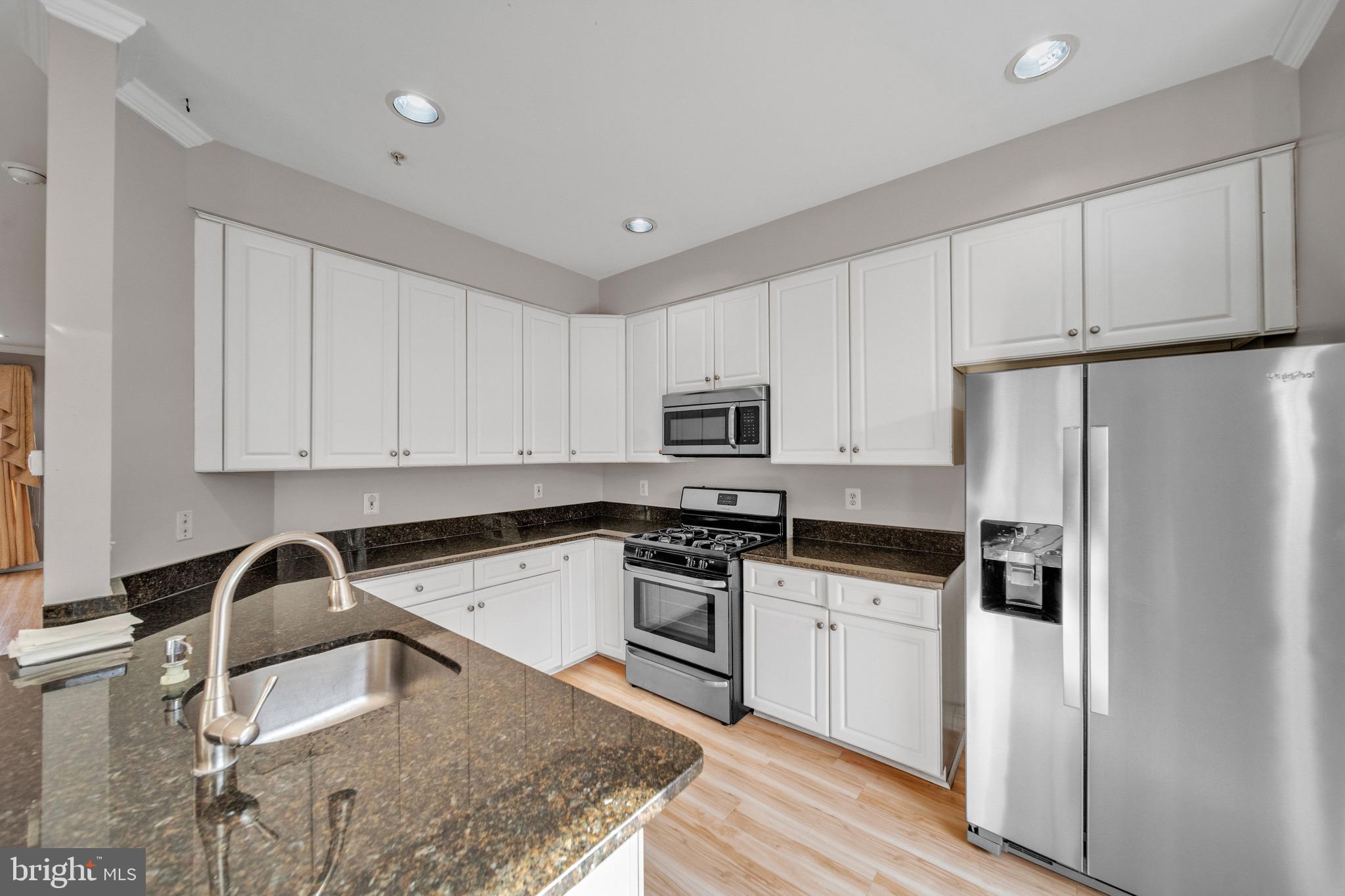 122 Longpoint Way Gaithersburg, MD 20878 - Photo 9 of 37 a kitchen with granite countertop white cabinets and stainless steel appliances