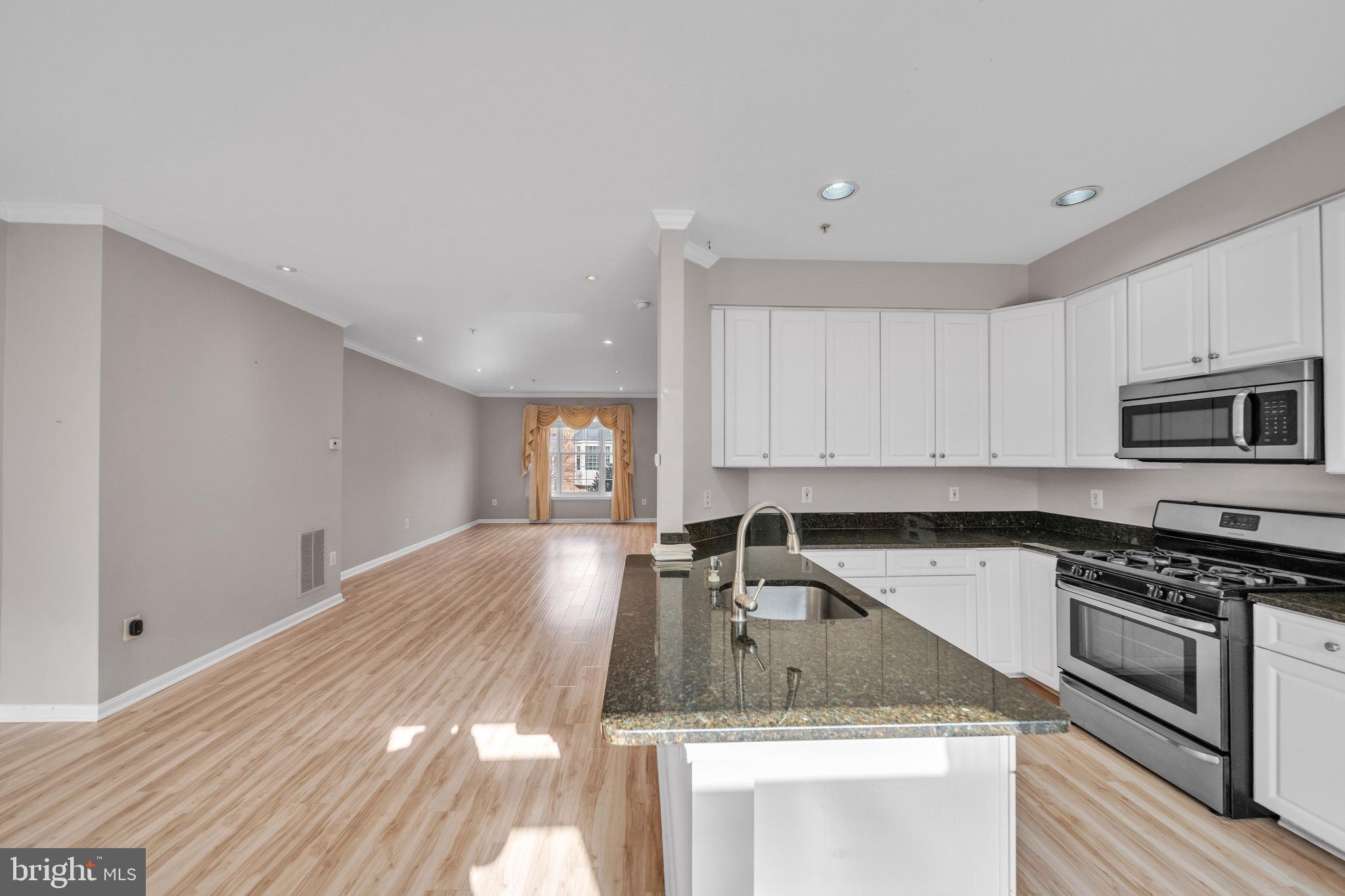 122 Longpoint Way Gaithersburg, MD 20878 - Photo 10 of 37 a kitchen with granite countertop a stove sink and cabinets