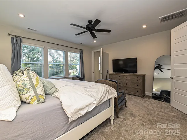 a spacious bedroom with a bed and a flat screen tv