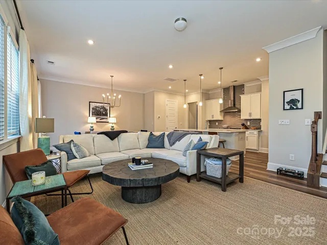 a living room with furniture kitchen view and a window
