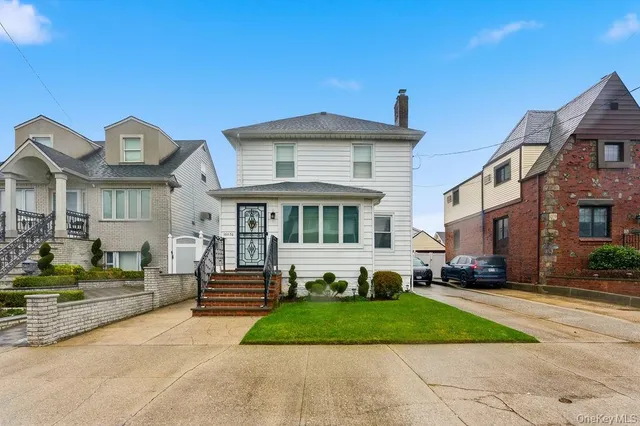 a front view of a house with a yard and potted plants