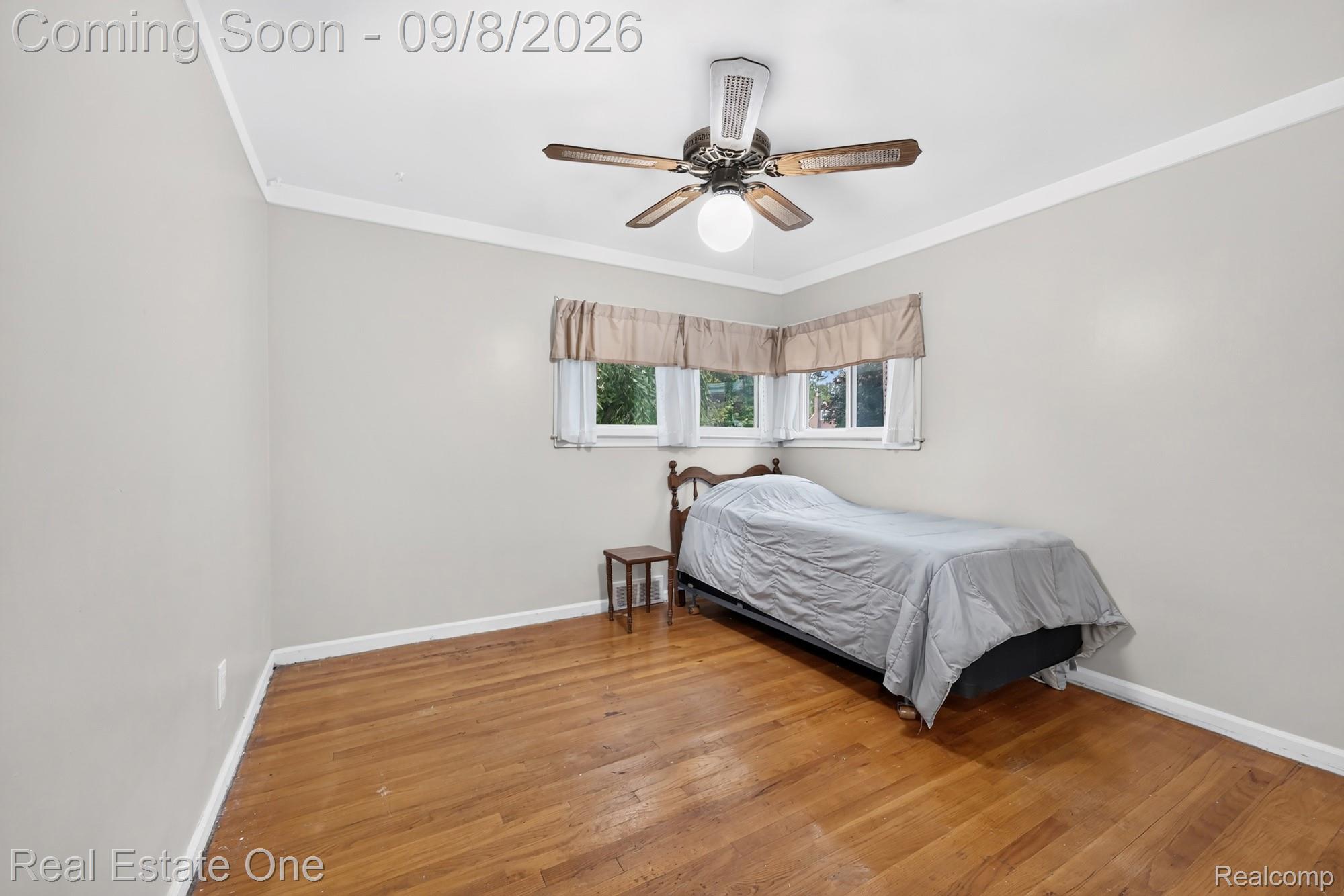 7961 Merrick Street Taylor, MI 48180 - Photo 15 of 39 Hardwood-style flooring with baseboard trim, corner windows, and a ceiling fan with integrated lighting