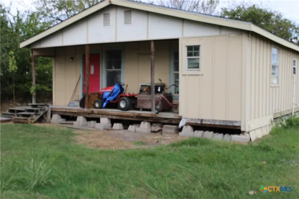 a view of backyard with small cabin and wooden fence