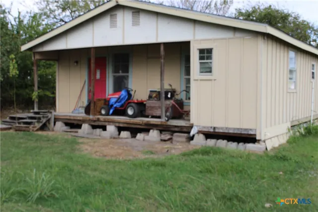 a view of backyard with small cabin and wooden fence