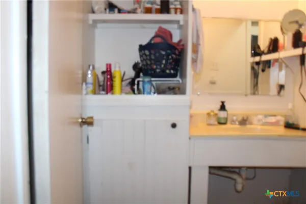a view of bathroom with a sink and mirror