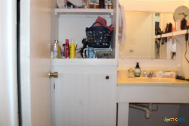 a view of bathroom with a sink and mirror