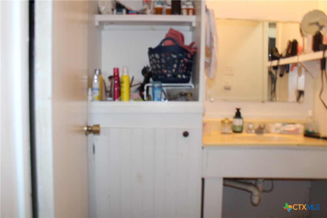 233 Indiana Street Bloomington, TX 77951 - Photo 6 of 16 a bathroom with a sink and a mirror