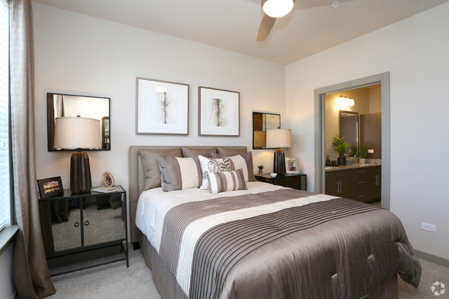 690 East Algonquin Road, Unit 1413 Schaumburg, IL 60173 - Photo 9 of 29 a bedroom with a bed and a lamp