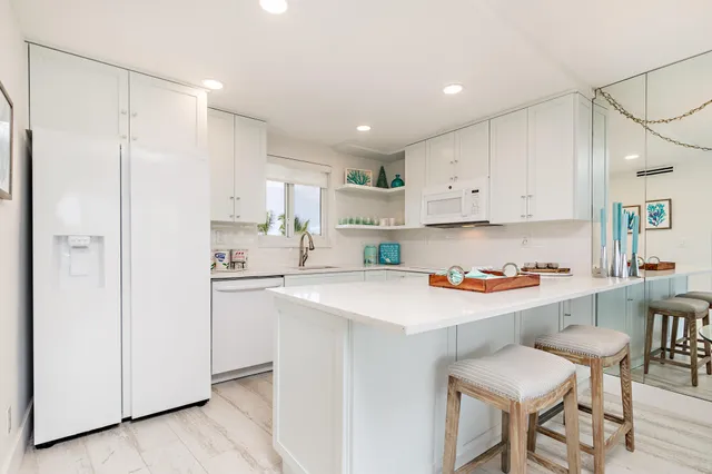 a kitchen with a sink a stove a refrigerator and white cabinets