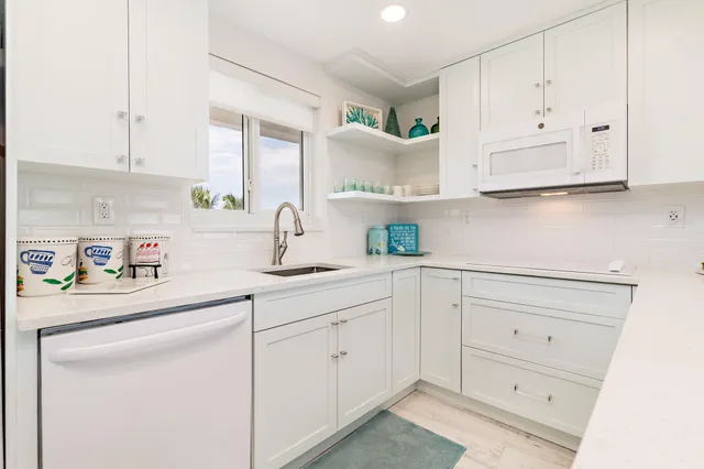 a kitchen with white cabinets and white appliances