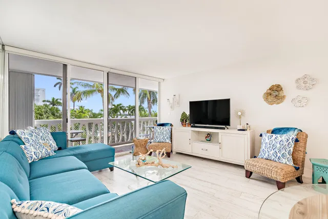a living room with furniture flat screen tv and a large window