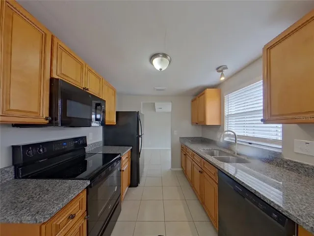 a kitchen with stainless steel appliances granite countertop a sink a stove and a microwave