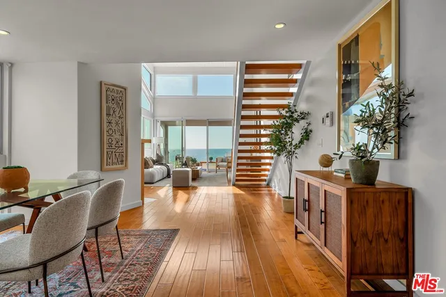 a living room with furniture a potted plant and a wooden floor