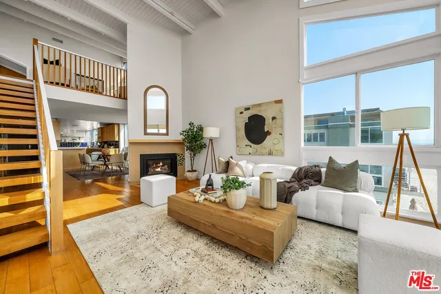 a living room with furniture a large window and a fireplace