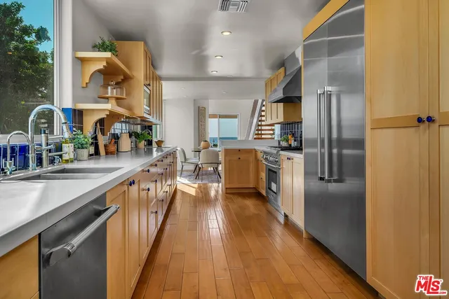a kitchen with stainless steel appliances granite countertop a refrigerator and a sink